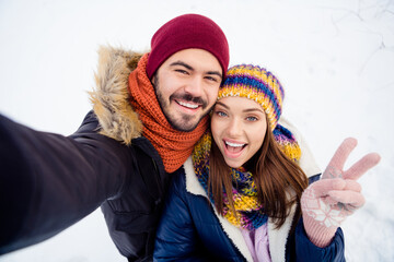 Photo of excited funny pretty lady handsome guy make selfie fingers show v-sign have fun weekend in woods outdoors