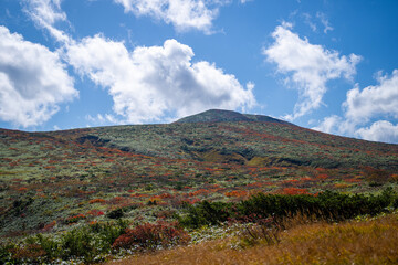 宮城県栗原市、秋田県湯沢市、雄勝郡東成瀬村、岩手県一関市にある栗駒山を紅葉の時期に登山する風景A view of climbing Mt. Kurikoma in Kurihara City, Miyagi Prefecture, Yuzawa City, Akita Prefecture, during the autumn foliage season.