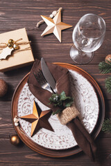 Christmas table setting with winter decor on wooden background.