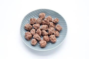 Dried salted Chinese plum in plate on white background