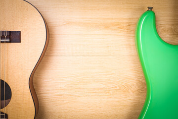 part of acoustic guitar versus electric guitar on wooden desk showing beautiful difference curve shapes design. music background