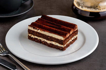 Gourmet Italian dessert tiramisu with brewed coffee on black stone table