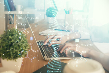 Double exposure of woman hands typing on computer and DNA hologram drawing. Medical education...