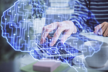 Double exposure of woman hands working on computer and brain hologram drawing. Ai concept.