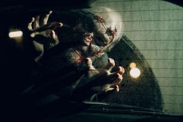 Zombie monster attack car driver through vehicle window glass halloween concept.