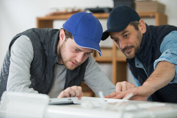 two workers install air conditioning