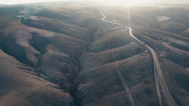 Aerial overhead shot of road 27 east of the town San Pedro de Atacama in the north of Chile in the Atacama desert at sunrise with sun flare