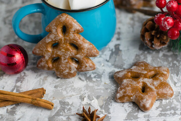 Christmas decor, delicious gingerbread cookies, marshmallows in a blue cup, star anise and cinnamon sticks on a light background. New Years celebration concept.