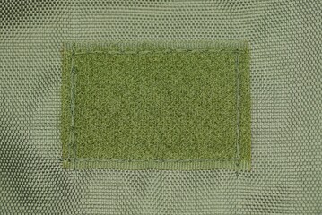 green fabric texture on a one rectangular sticky buckle on a backpack