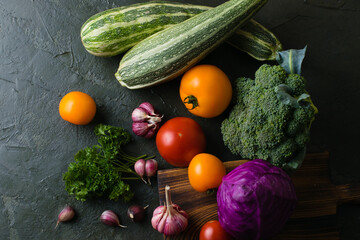 Healthy nutrition concept. Lots of vegetables on a dark table top, view from the top
