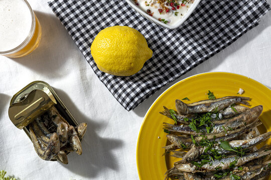Grilled anchovies served on table with beer glass and white soup