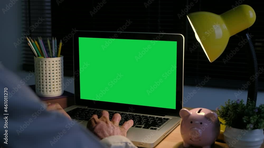 Poster back view of businessman hands typing and scrolling on a track pad with chroma key green screen lapt