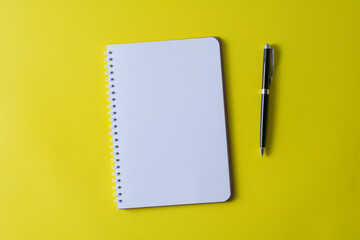 Top view of blank open notebook on yellow background and different objects. Minimal flat lay style. © youlanda