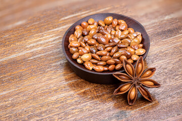 Dried star anise or Illicium verum fruits and seeds on an old wood background.