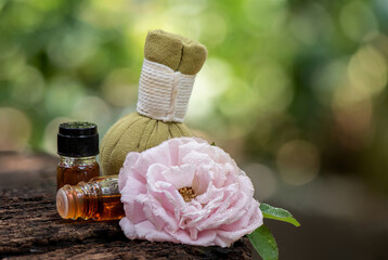 Aromatherapy with damask rose flower and perfume in herbal compress on green leaves bokeh natural...