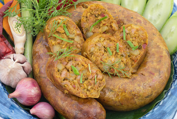 Sai aua or northern thai spicy sausage contains herbs such as Lemongrass, kaffir lime leaves, coriander and more isolated on white background.