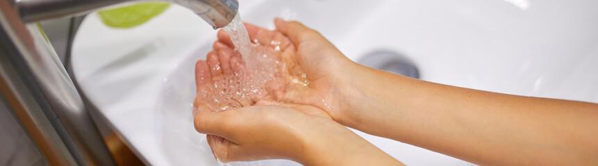 Fototapeta premium Little girl washing hands with soap in the bathroom