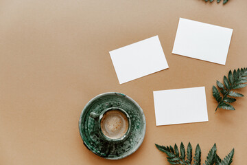 Blank paper card and a cup of coffee. Minimalist concept  Mock up or template, copy space, flat lay. .