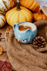 Autumn composition with coffee, autumn leaves, warm sweater and  pumpkins on wooden background, Autumn still life,  Autumn, fall, halloween, thanksgiving day concept.