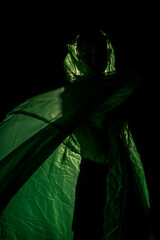 Girl posing in green draping on dark background