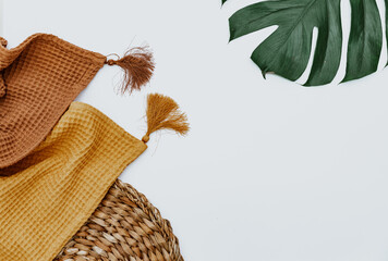 Two blankets and monstera leaf on white background, minimal simple background