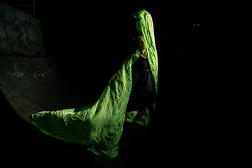 Girl posing in green draping on dark background