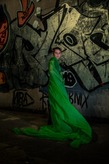 Girl posing in green draping on dark background