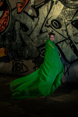 Girl posing in green draping on dark background