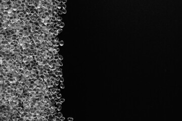 White granules of rubber, polypropylene or polyamide on a black background.