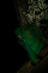 Girl posing in green draping on dark background
