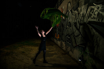 Girl posing in green draping on dark background