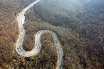 Aerial view of mountain road between Vozrozhdenie and Mikhaylovsky Pereval villages on winter day. Krasnodar Krai, Russia.