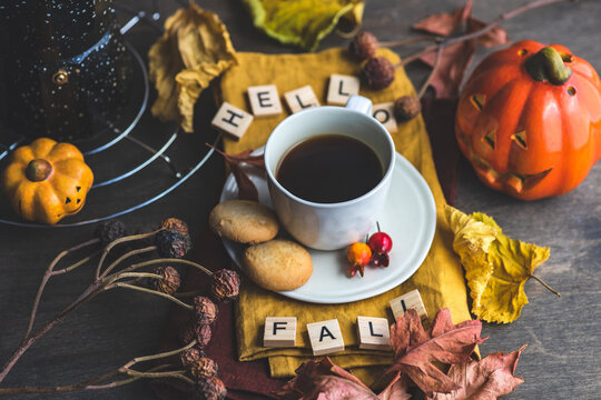 Cup of coffee with cookies surrounded by Autumnal decorations