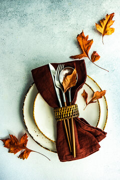 Autumnal rustic table setting with fall foliage decorations