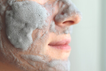 A young woman with a cleansing mask on her face close-up, with a place to copy the text
