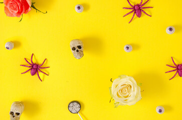 Colorful Halloween concept with skulls, spiders, and eyeballs on vivid yellow background. Creative spooky celebration idea.