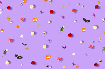 Halloween concept with skull, spiders, pumpkins, bats, and eyeballs on purple background. Creative celebration idea.