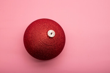 big bright red christmas ball on a pink background
