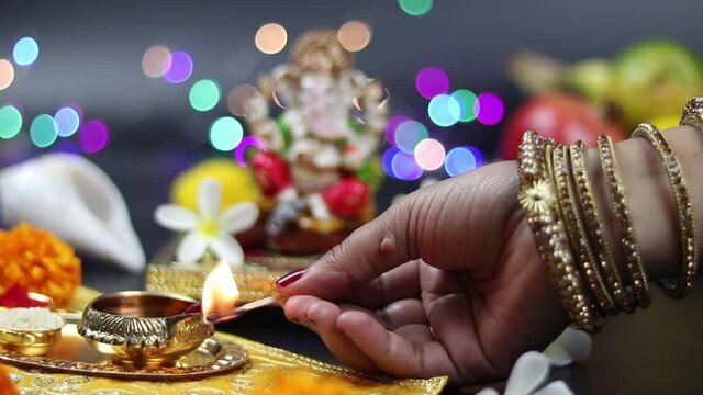 Married Girl Wearing Bangles Lits Brass Diya Or Deep In Front Of Hindu God Lord Ganesha Ganpati Bappa Morya For Worship On Diwali Puja New Year Deepawali Ganesh Chaturthi Or Shubh Deepavali Pooja