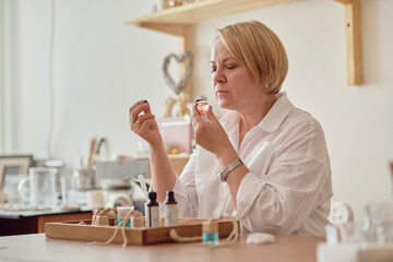 Close-up of a pipette with oil and a glass bottle. woman pouring perfume in bottle. Perfume creating workshop