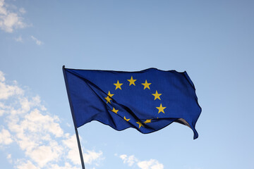 European Union EU flag waving in clear blue sky - obrazy, fototapety, plakaty