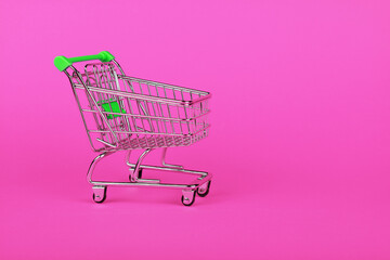 Close up retail shopping cart over pink