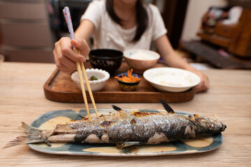 焼き魚を食べる子供