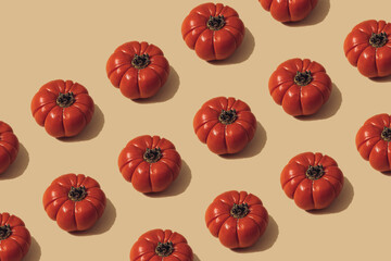 Autumn sunlit yellow background with pumpkins or tomatoes. Flat lay harvest or halloween concept. Creative layout of colorful vegetables. Copy space.