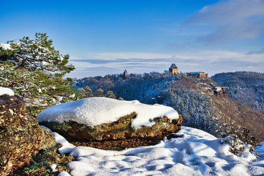 Castle Nideggen, Germany in winter mountain landscape and snow covered rock in foreground