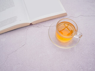 Top view of a teacup and a book on a cement background with copy space for text. Relaxation concept