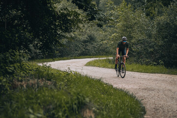 Fototapeta premium Muscular man in sport clothes riding bike on trail