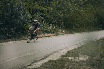 Cyclist in helmet and glasses having training outdoors