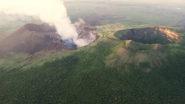 Cinemaic Aerial view over 2 volcano craters. Active volcano full of steam and inactive covered with vegetation  . Erupting Volcano in Central America. Masaya, &ldquo;Mouth of Hell&rdquo;, Nicaragua. Close up shot
