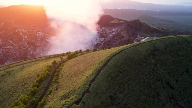 Aerial shot over a crater full of  steam from Erupting Volcano in Central America durung sunset. Masaya, the &ldquo;Mouth of Hell&rdquo;, Nicaragua. Close up